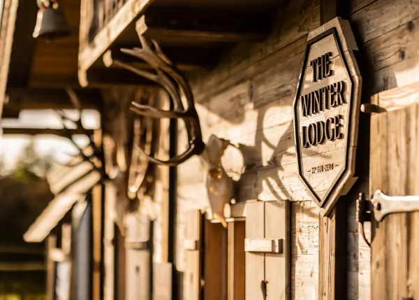 Interior of a rustic barn venue with exposed beams and warm festoon lighting