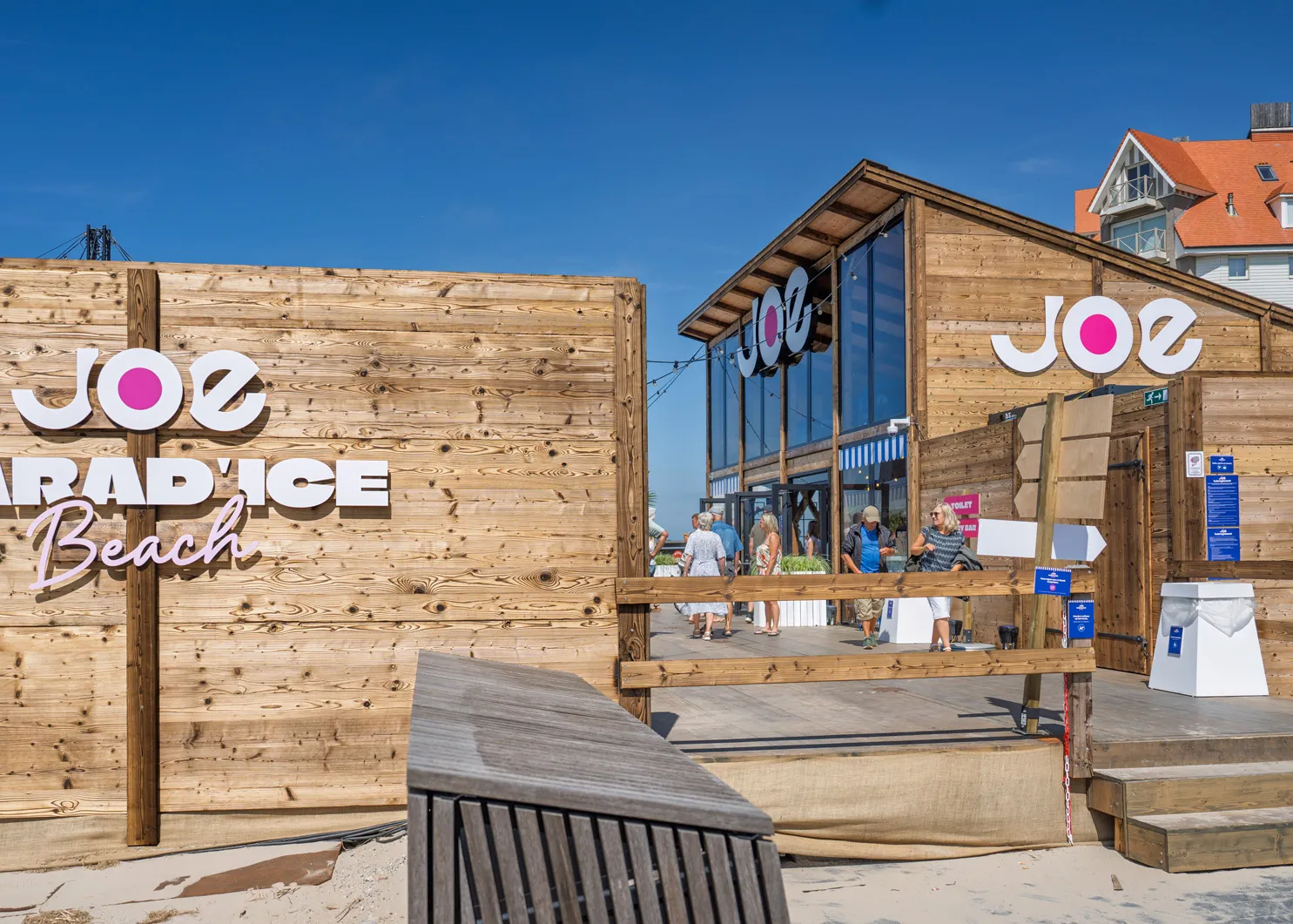 Interior of a rustic barn venue with exposed beams and warm festoon lighting