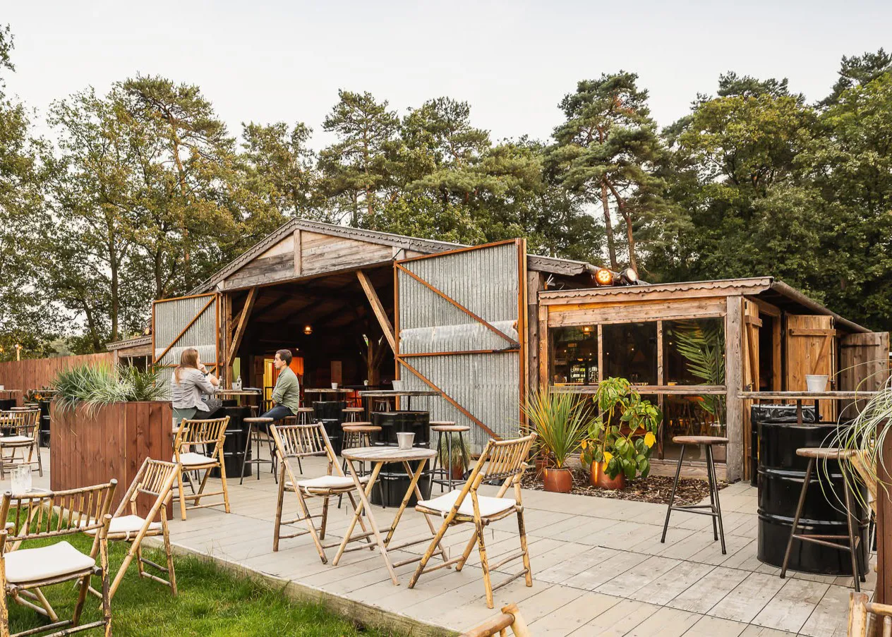 Exterior view of a rustic barn-style event structure with timber cladding and pitched roof