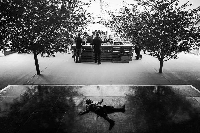 Bride and groom walking through guests as confetti falls beneath a leafy archway